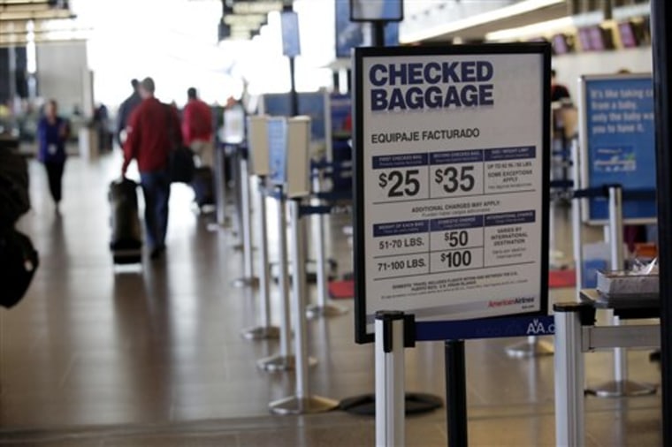 An American Airlines sign at Seattle-Tacoma International Airport lists the fees for checked baggage.